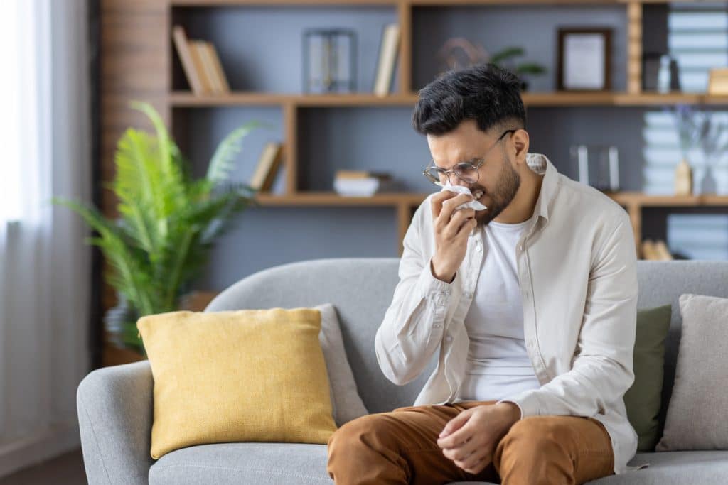 man wipes his nose